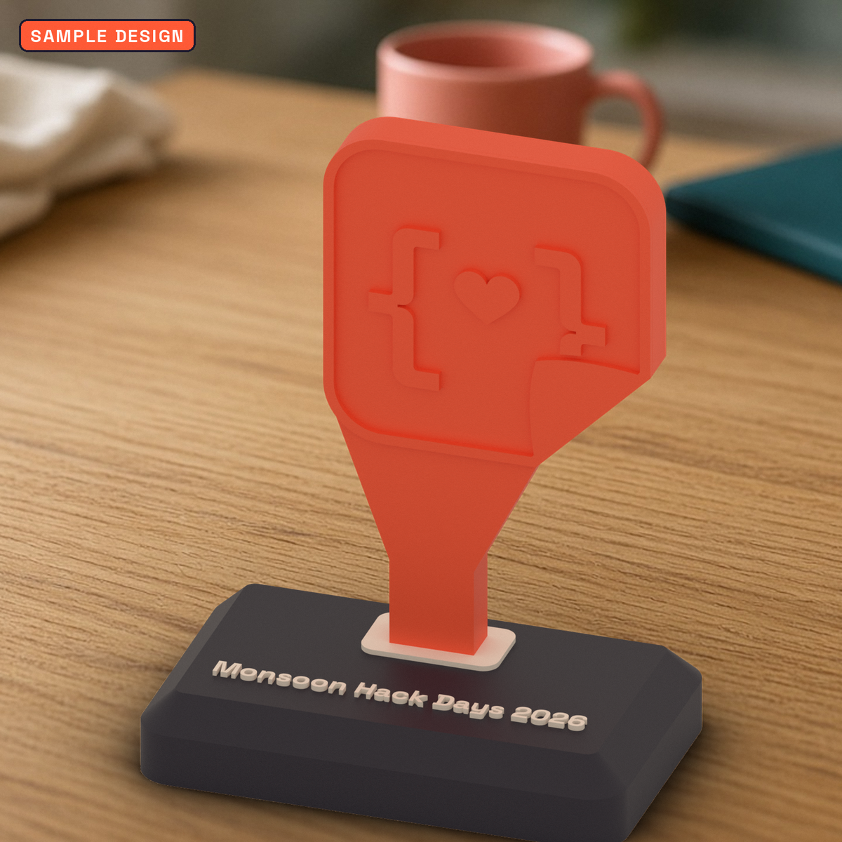 Custom 3D printed conference trophy in coral with the StickerCon logo on a dark base reading Monsoon Hack Days 2026, on a wooden desk, sample design for a made-up event