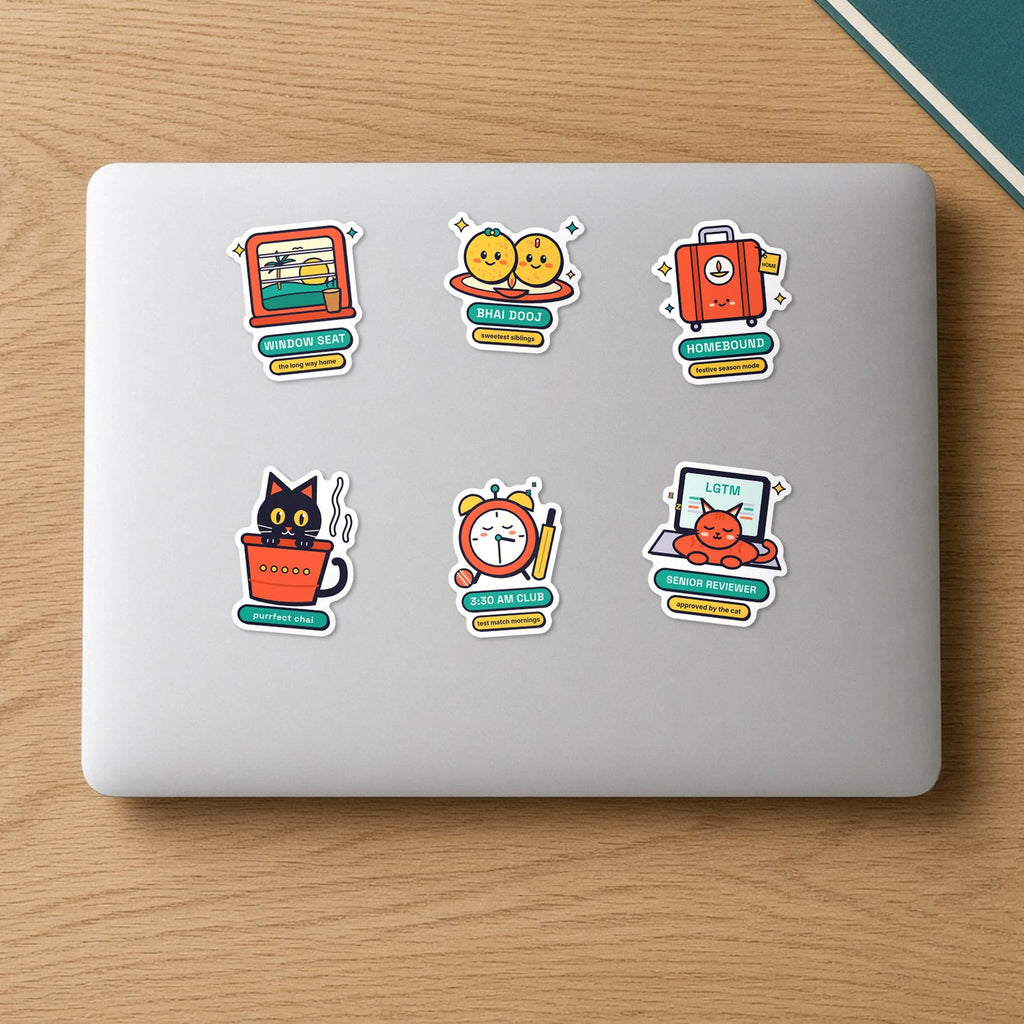Going Home Sticker Pack: six die-cut vinyl stickers on a laptop lid, including Window Seat, Homebound suitcase, Kulhad Cat, Laddoo Siblings, 3:30 AM Club and Senior Reviewer