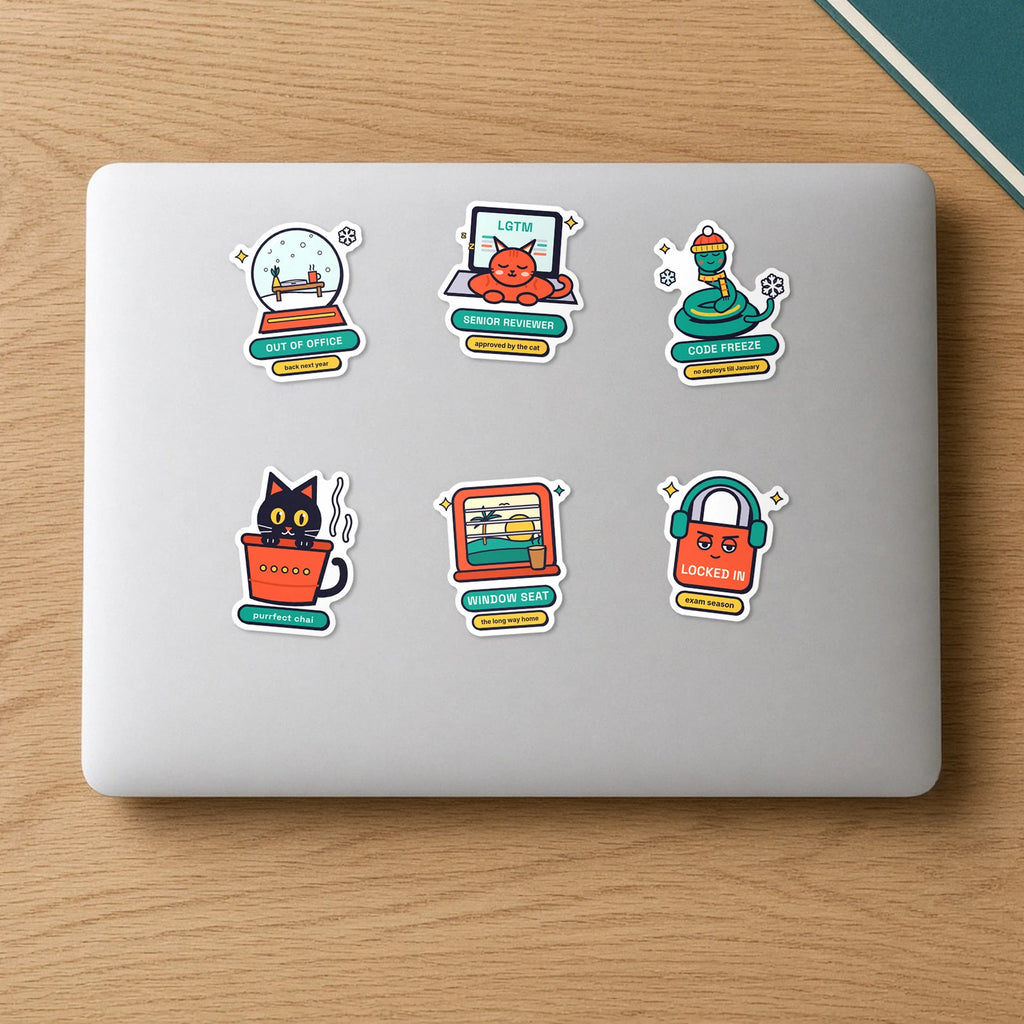 Holiday Mode Sticker Pack: six die-cut vinyl stickers on a laptop lid, including Out of Office snow globe, Code Freeze Pip, Kulhad Cat, Senior Reviewer, Window Seat and Locked In