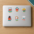 New Drops Sticker Pack: six die-cut vinyl stickers on a laptop lid, including Kulhad Cat, Locked In, BOOlean Ghost, 3:30 AM Club, Senior Reviewer and Laddoo Siblings