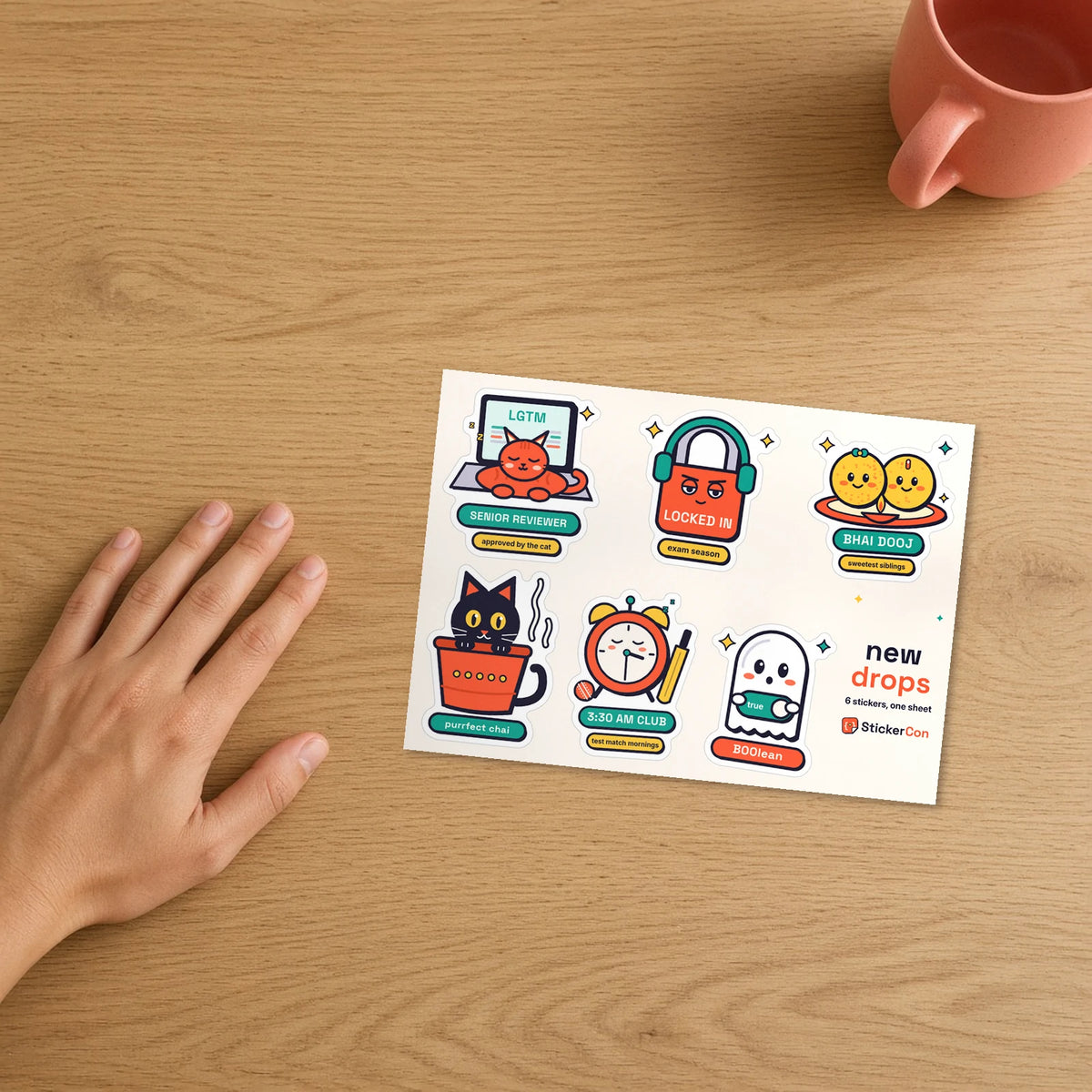 New Drops Sticker Pack 5 x 7 inch kiss-cut sheet on a desk beside a hand for scale