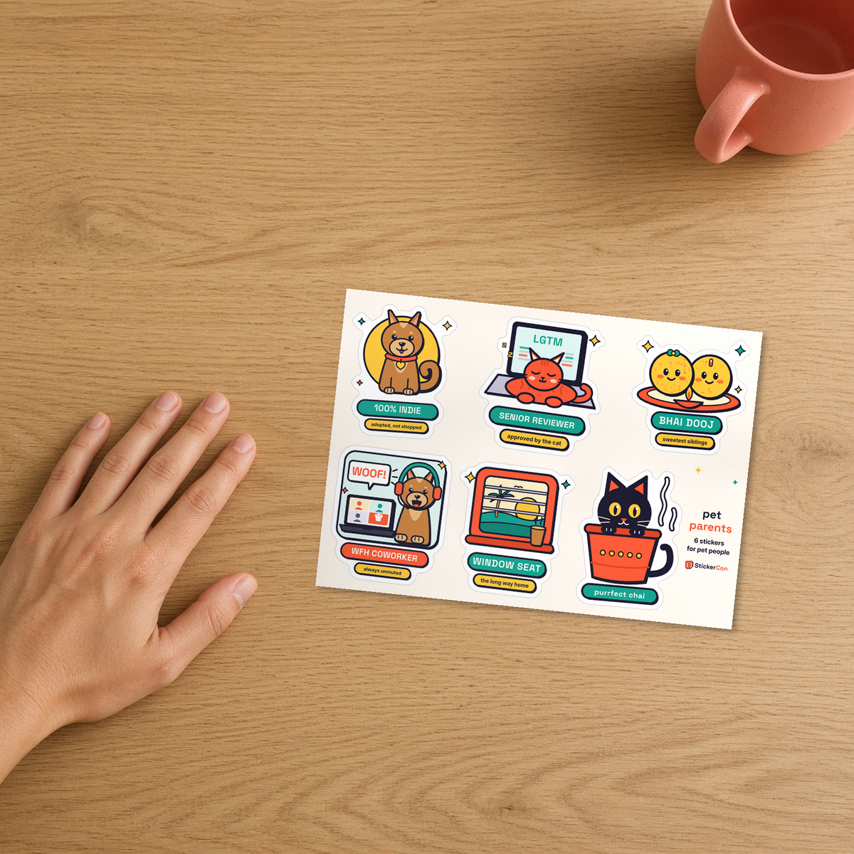 Pet Parents Sticker Pack 5 x 7 inch kiss-cut vinyl sheet on a desk beside a hand for true scale