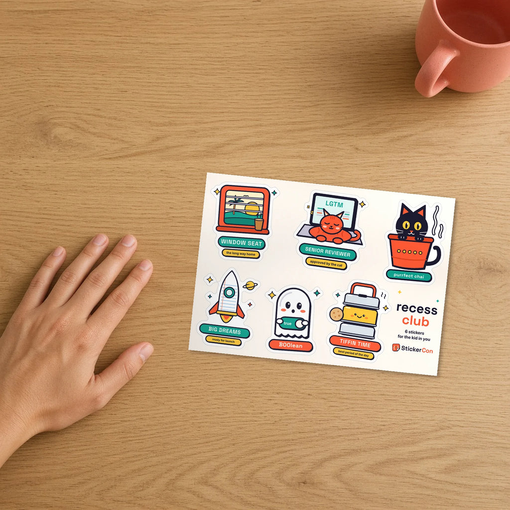 Recess Club Sticker Pack 5 x 7 inch kiss-cut vinyl sheet on a desk beside a hand for scale